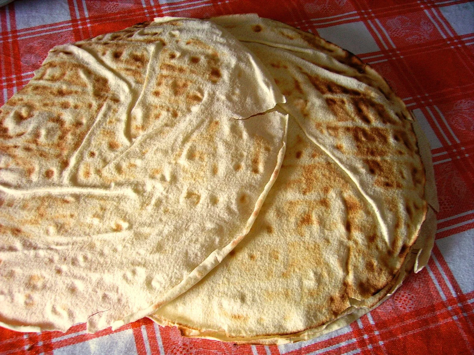 Sfoglie di pane carasau appoggiate su una tovaglia a quadri